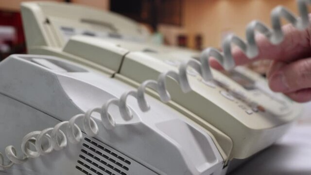 Men's Hand Dials On The Number Buttons On The Old Dirty Fax Telephone. A Man's Hand Picks Up The Phone And Dials A Phone Number On The Dust White Keyboard Of A Landline In The Office.