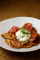 Traditional steamed dumplings with tomato sauce and sour cream. Restaurant serving dishes close-up.