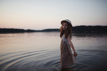 little cute girl with long hair on the lake