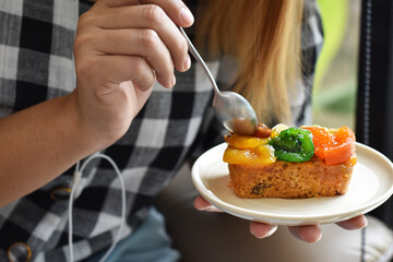 Close-up view, Eating fruit cake on ceramic dish in coffee shop.