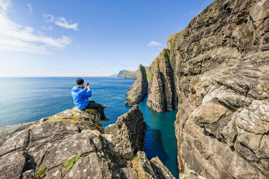 Traveling man on rock near sea