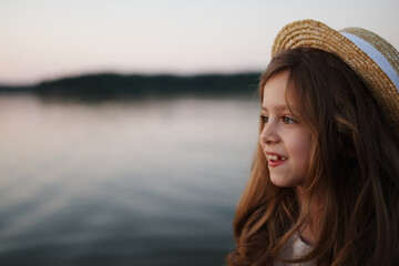 little cute girl with long hair on the lake