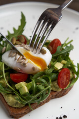 Poached egg toast with guacamole avocado sauce.