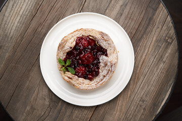 Puff pastry cake with berries on wooden background.
