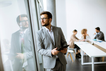 Young modern businessman using  digital tablet in the office