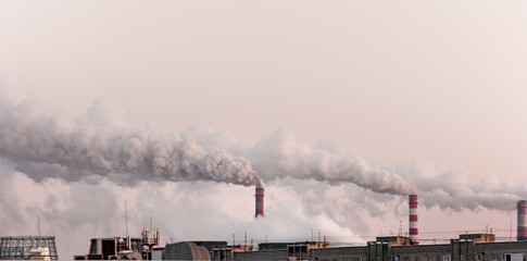 Fototapeta na wymiar copy space with industrial chimneys with heavy smoke causing air pollution on the pink and gray smoky sky background