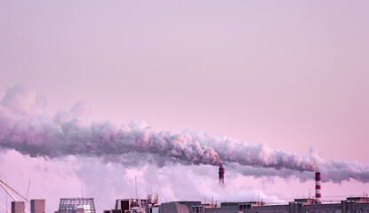 copy space with industrial chimneys with heavy smoke causing air pollution on the pink and gray smoky sky background