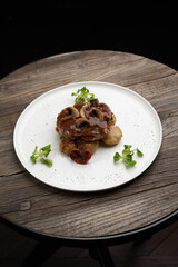 Beef stew with potatoes and mushroom on white plate