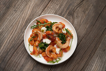 Gnocchi with shrimp and baked tomatoes. Italian seafood