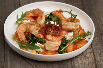 Gnocchi with shrimp and baked tomatoes. Italian seafood