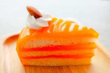 Orange cake on a wooden plate and a white background 
