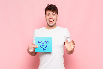 young man feeling happy, excited, surprised or shocked, smiling and astonished at something...