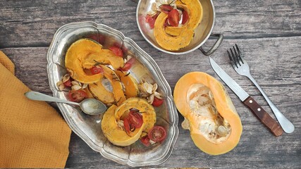 Roasted slices of pumpkin and cherry tomatoes on a silver tray