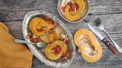 Roasted slices of pumpkin and cherry tomatoes on a silver tray