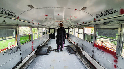 Wide angle rear shot of a man inside a bus being renovated. No seats, empty floor, ready for...