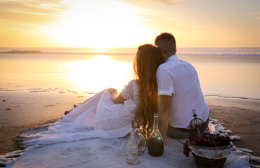 A gentle romantic date on the ocean during the magical sunset. A girl and a guy in white clothes...