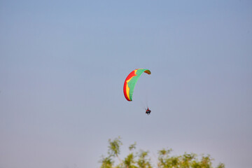 Paragliding in the sky. Paraglider flying in bright sunny day. Beautiful paraglider in flight on a...