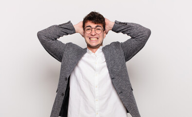 young man feeling stressed, worried, anxious or scared, with hands on head, panicking at mistake