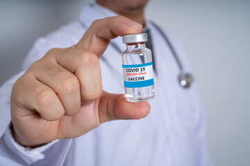 Male Doctor wearing PPE with a stethoscope on shoulder and holding syringe COVID-19 vaccine CORONA vaccine concept Healthcare and Medical