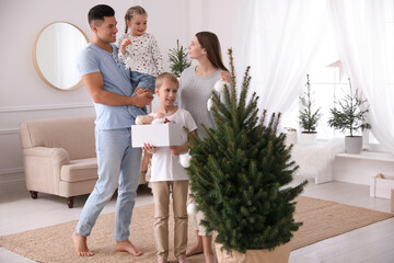 Happy family with cute children decorating Christmas tree together at home