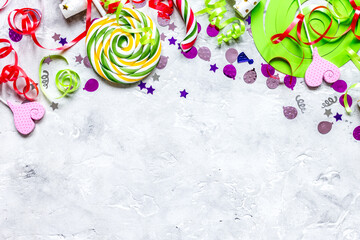 Fototapeta na wymiar Colored party sweets and confetti on stone background top view mockup