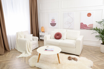Fototapeta na wymiar Stylish living room interior with comfortable sofa and pictures