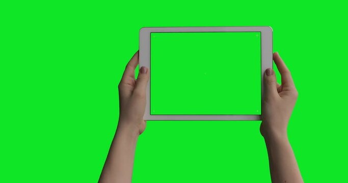 iPad Air Tablet In Female Hands isolated on green screen background with alpha channel luma matte. Pre Keyed for easy screen replacement. Mock-up for your content.