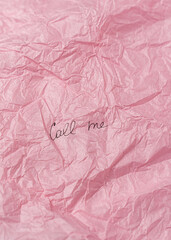 Words Call me on creased pink tissue paper