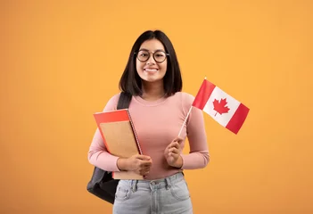 Papier Peint photo Canada Voyages, éducation moderne et échange d& 39 étudiants. Jeune femme asiatique joyeuse dans des verres avec des cahiers