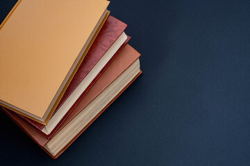 old books with brown covers on a black table