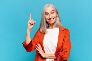 middle age woman feeling like a happy and excited genius after realizing an idea, cheerfully...