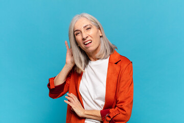 middle age woman looking serious and curious, listening, trying to hear a secret conversation or...