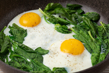 scrambled eggs with spinach in a pan
