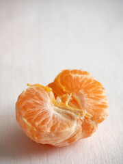 Fresh juicy bright orange tangerines with green leaves on a white cotton tablecloth in the morning light