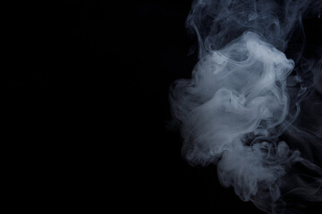 Abstract white smoke moves on black background. Beautiful swirling gray smoke.