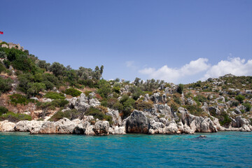 Fototapeta na wymiar Lycian sarcophagus on the hill on coast of Mediterranean Sea. turquoise water. Turkey.
