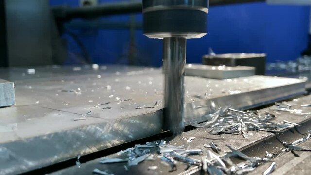 Working a milling machine at the plant. metal shavings fly. remove chips from the machine with a brush. High quality 4k footage