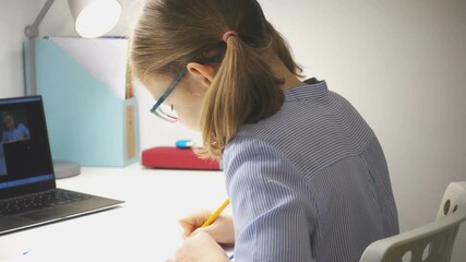 Cute school girl at online lesson with her teacher using laptop during digital homeschooling - Powered by Adobe