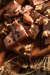 Pieces of pink and dark chocolate on rustic wooden background