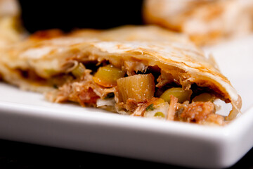 Comida mexicana, com deliciosa culinária mexicana, construção 45º sobre fundo preto. Nachos, burritos, guacamole, tacos, pimenta etc.