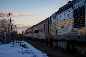 Obraz premium Old diesel locomotive carrying retro passenger wagons 