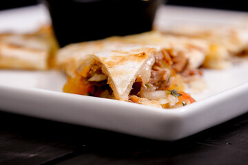 Comida mexicana, com deliciosa culinária mexicana, construção 45º sobre fundo preto. Nachos, burritos, guacamole, tacos, pimenta etc.