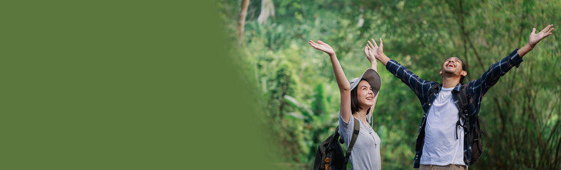 Banner or web header ratio image. Happy couple hiking outdoors in forest. Active young Caucasian...