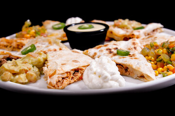 Comida mexicana, com deliciosa culinária mexicana, construção 45º sobre fundo preto. Nachos, burritos, guacamole, tacos, pimenta etc.