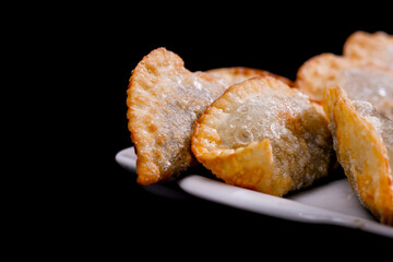 Deliciosos pasteis de carne, camarão, queijo com creme de queijo gorgonzola em recipiente branco em fundo escuro.