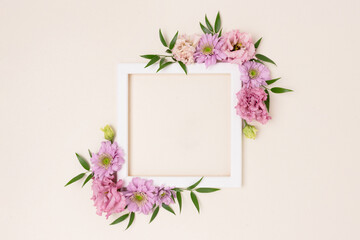 Square flower frame made of pink eustoma on a beige background. Greeting card template with copyspace. Romantic concept.