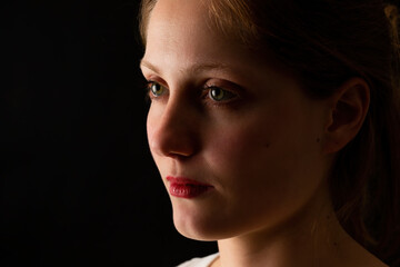 Unhappy woman looking without smile on black background. Depressed female with red lipstick from...