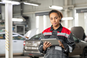 Young car service worker looking at you while scrolling through online questions