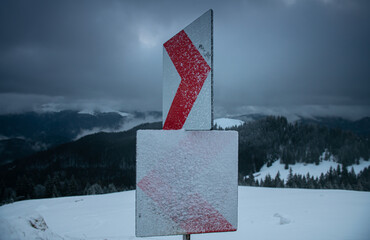 Traffic sign turn in winter landscape on top of the mountains