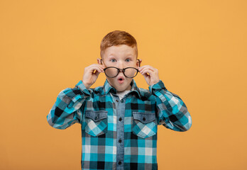 Shocked kid in glasses keeping mouth open